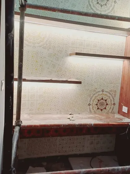 We designed this intricate mandala and geometric pattern for a study nook. The subtle, tone-on-tone stencil work is enhanced by integrated LED strip lighting under the shelves, highlighting the detailed design and creating a warm, focused workspace.