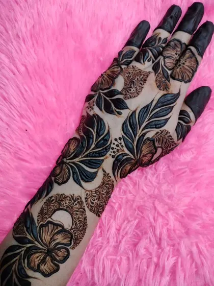 A bold and beautiful Arabic floral design with dark, shaded leaves and flowers. The pattern covers the entire back of the hand for a dramatic look.