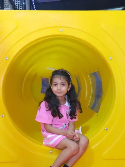 Peeking out from a play tunnel. Our structures are designed with fun little nooks and passages for kids to discover and explore.