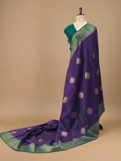 A stunning pure Dupion Banarasi silk saree in purple with a contrasting green border and gold butis.