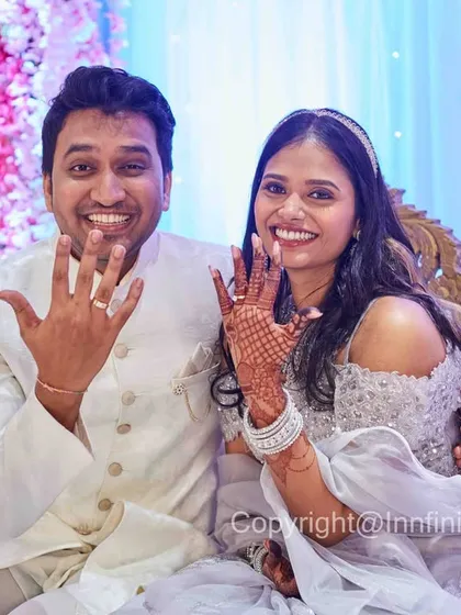 A bright, happy portrait of the newly engaged couple showing their rings while seated. Their smiles convey the excitement of the occasion.