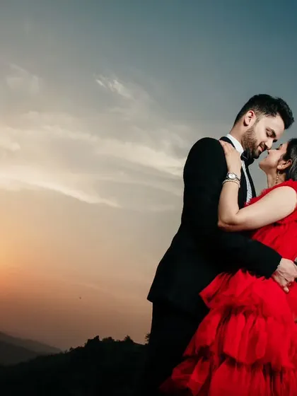 A romantic close-up during a golden hour pre-wedding shoot. The warm light of the setting sun beautifully illuminates the couple as they share an intimate moment.