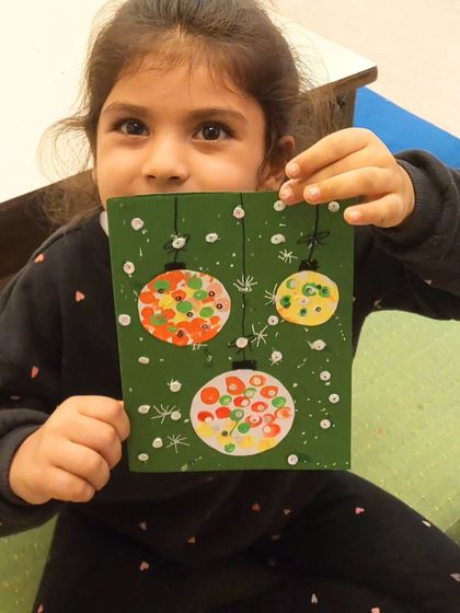 A close-up of a Christmas card created by one of my youngest students. Using simple dot patterns, she made these beautiful, sparkling ornaments.
