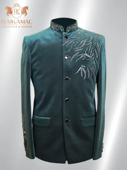 A deep green velvet Jodhpuri suit, exuding royalty. This piece features delicate silver embroidery on the shoulder and sleeve, perfect for a regal entrance.