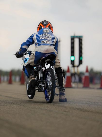 The Christmas tree lights go green, and a custom drag bike launches with its front wheel in the air. This is the explosive start to a high-stakes quarter-mile run.