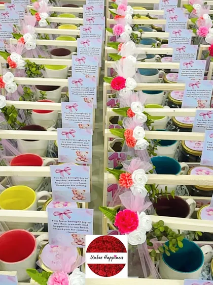 An overhead view of the colorful mugs included in the pink teddy bear return gifts, showing the variety of colors available.