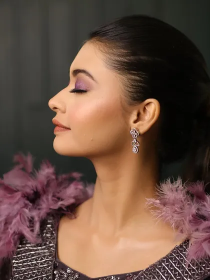 A beautiful profile shot of this dramatic purple eye makeup. The blending is seamless, creating a look that is both bold and beautifully executed.