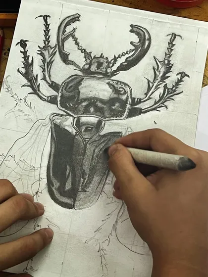 Observational drawing is a cornerstone of a strong portfolio. This detailed beetle sketch shows a mastery of pencil shading, texture, and proportion. I teach students to look closely at the world around them, from bugs to teacups, and translate it onto the page with precision.
