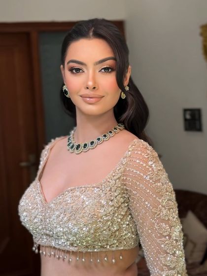 A close up of the half up, half down hairstyle. The front sections are pulled back smoothly, while the rest of the hair flows in structured waves.