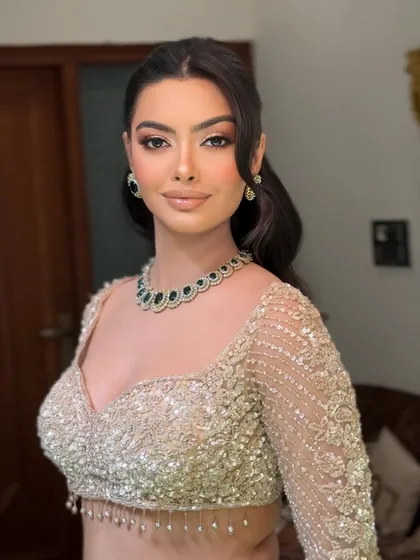 A close up of the half up, half down hairstyle. The front sections are pulled back smoothly, while the rest of the hair flows in structured waves.