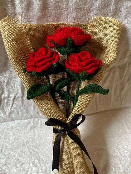 A simple yet beautiful bouquet of three crochet red roses. We wrapped them in natural burlap with a black ribbon, creating a rustic and romantic look that's perfect for a sweet, simple gesture.