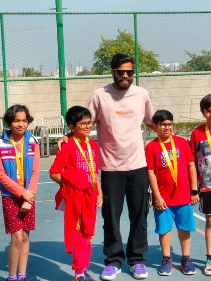 The coach with a team of young medalists after their performance in the Inter-Society basketball matches. Building confidence is as important as building skills.