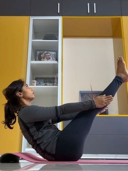 A student holds Ardha Navasana (Half Boat Pose) during an online session. This pose is excellent for toning the abdominal muscles and improving digestion.