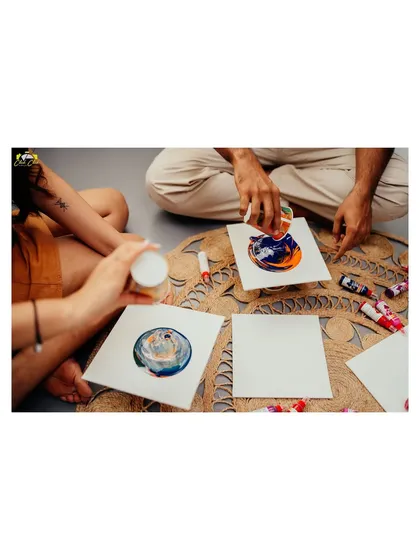 A close-up of the couple's hands as they create their fluid art paintings, a symbol of creating something beautiful together.