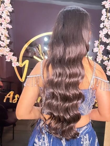 The back view of a long, open hairstyle with soft, uniform waves. This simple yet elegant style is perfect for showing off long, healthy hair.