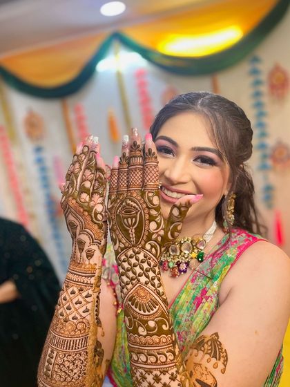The bride's joyful expression says it all as she shows off her full bridal mehandi.