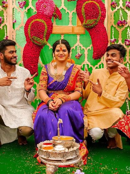 A playful portrait of the bride with her brothers or groomsmen, all pointing at her with big smiles.