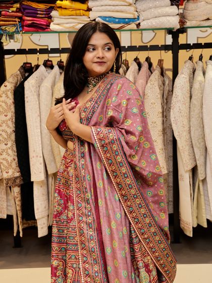 Here is another angle of the pink lehenga with the printed dupatta. The mix of patterns and colors makes it a joyful and festive outfit choice.