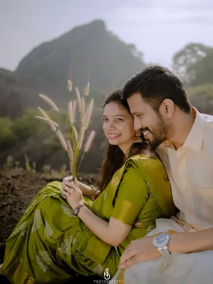 A close-up shot with natural grasses used as a foreground element. This creative framing adds an artistic touch to the couple's portrait.