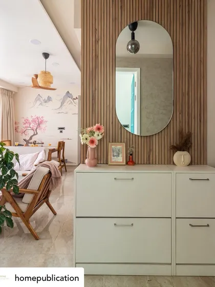 A repost from a home publication featuring our Japandi project. The foyer sets a graceful tone with an oval mirror on a louvered panel and limewash stucco walls.