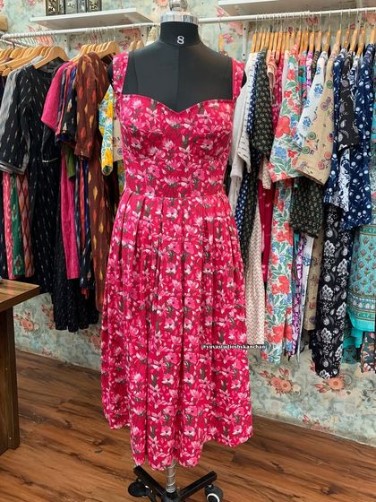 My flared one-piece dress in a vibrant pink floral print, seen here on a mannequin. The sweetheart neckline and pleated skirt make it a perfect choice for a date night.