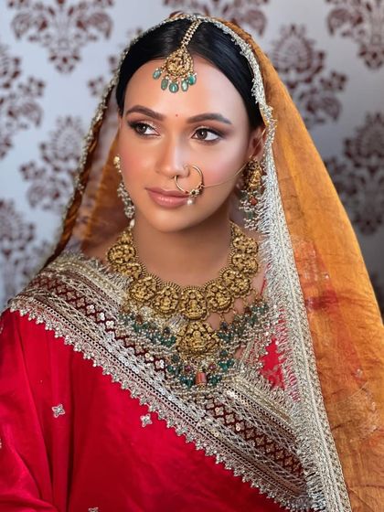 A close-up of the bride's regal look, her hair perfectly styled to showcase her stunning temple jewelry.