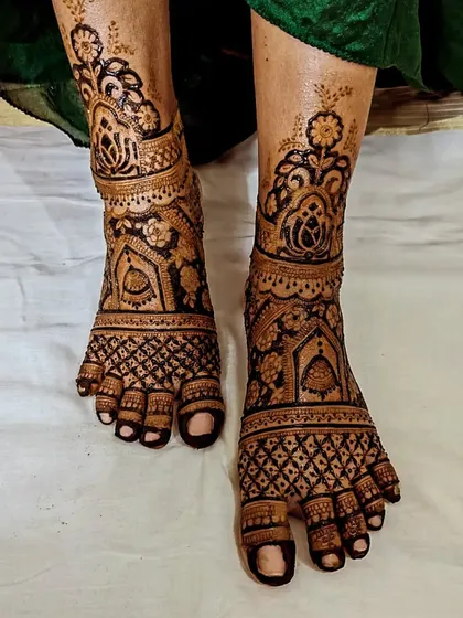 Your mehendi celebration isn't complete without adorning your feet. This is a full-coverage traditional foot mehendi, featuring intricate netting and bold floral patterns.