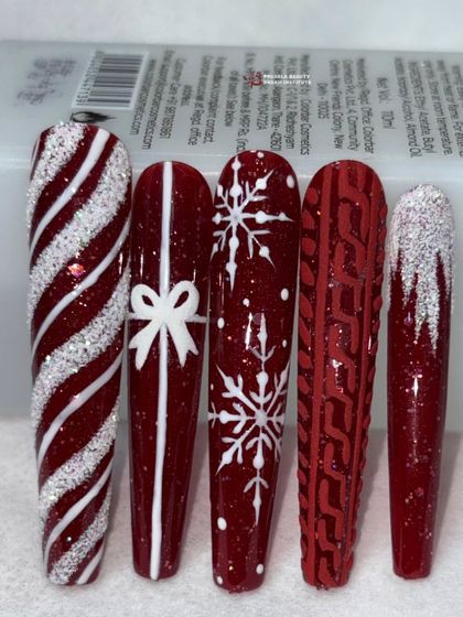 A close-up of the red Christmas nails, highlighting the 3D bow and the textured sweater pattern.