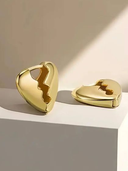 A product shot of the broken heart gold plated earrings, showing their unique and modern design.
