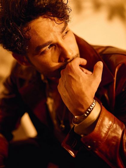 This tight shot on Siddhant Chaturvedi emphasizes the rich color of the leather jacket and the thoughtful details, like the stacked bracelets, that finish the look.