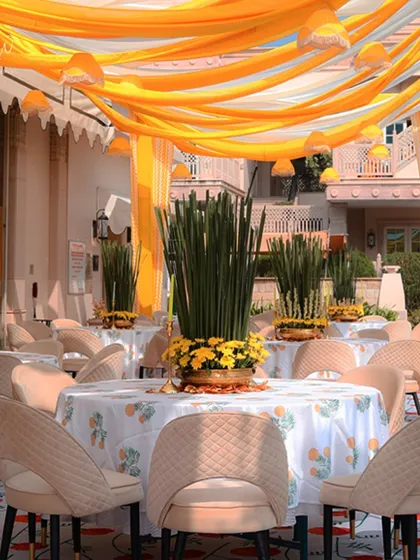 The guest seating area, with tables covered in custom-printed linens and a ceiling of yellow and white drapes, creating a festive and cohesive look.