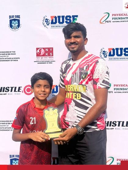 Aayansh Bhanushali receives the Player of the Match award from a coach after a winning performance at the DUSF Grassroots Football Fiesta.
