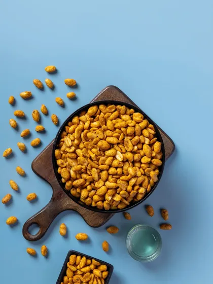 Spicy coated peanuts against a cool blue backdrop. This is another example of how I use color theory in product photography to create a specific mood for packaging.
