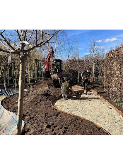 The construction phase of the garden in France. Here, our team carefully lays the gravel path and defines its edges, working with the natural contours of the land to create a flowing, organic shape.