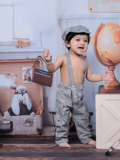 A joyful toddler in our vintage traveler set, complete with globes, old maps, and model airplanes.