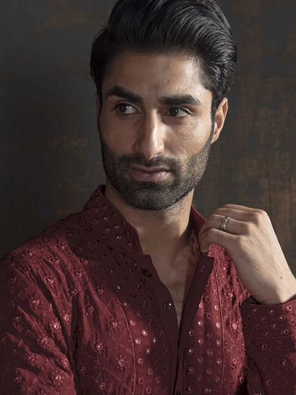 A close-up of a rich maroon kurta with delicate, all-over embroidery. This piece redefines elegance in traditional wear, celebrating both culture and style.