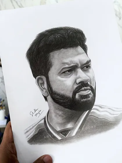 A hand-held view of the completed Rohit Sharma pencil sketch. This shows the artwork on paper, giving a sense of its scale and texture before framing.