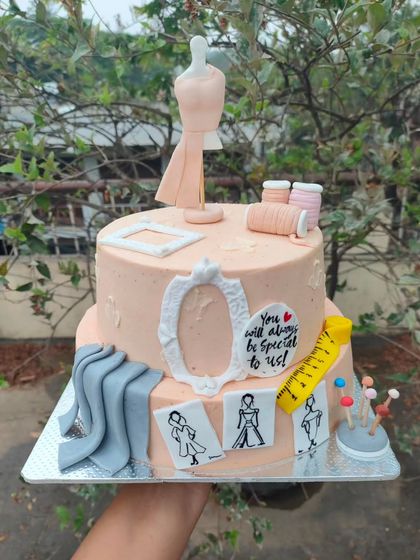 You're "sew" cute. A two-tier cake designed for a fashion designer, complete with a mannequin, fabric swatches, spools of thread, and fashion sketches.