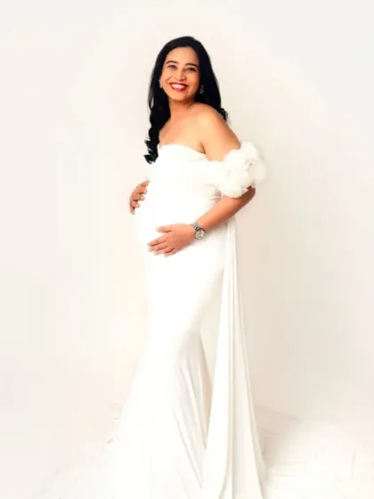 A full-length shot of our elegant white fitted gown with off-the-shoulder ruffle details and a small train.