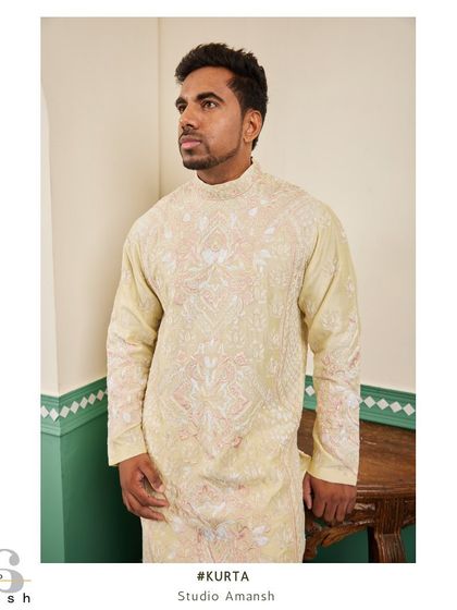 A three-quarter view of the heavily embroidered yellow kurta, a true statement piece for a grand celebration.
