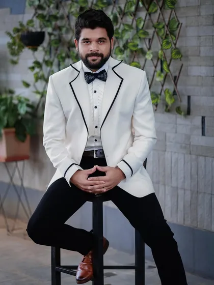 For this photoshoot with Kshitish Date, I chose a striking white tuxedo with black piping. It’s a bold, high-contrast look perfect for making a statement.