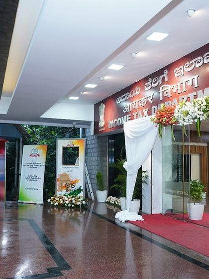A welcoming entrance with a floral arch and red carpet at the Income Tax Department. Our decor services create a distinguished and inviting atmosphere for government functions.