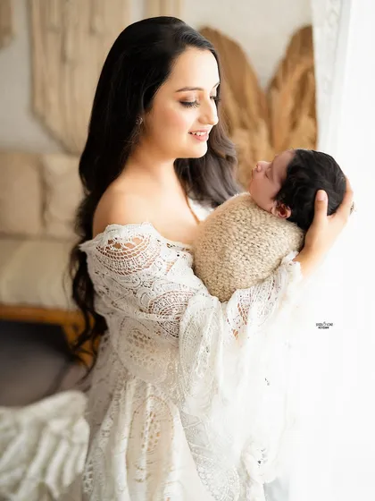 A mother gazing lovingly at her newborn baby, a quiet and beautiful moment.