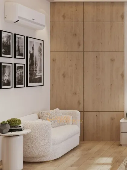 A comfortable seating nook within the bedroom, featuring a boucle sofa against a warm wood-paneled wall, perfect for relaxation.