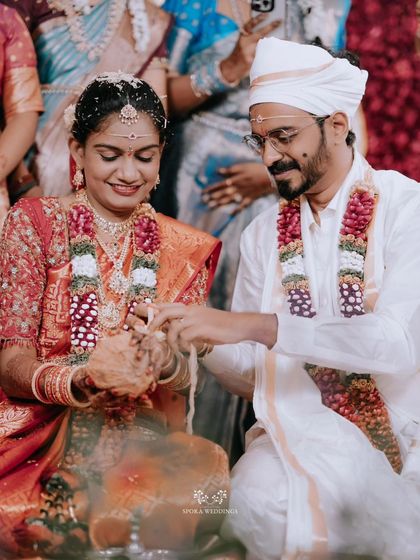 The couple performing a ritual with water and grains, a symbol of prosperity and blessings for their new life.