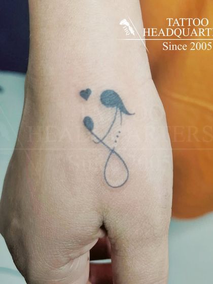 A minimalist tattoo symbolizing a mother and child, created with a few simple, elegant lines.