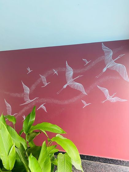Using just lines and dots, we created this mural of birds in flight. The delicate white artwork on the deep red wall gives a sense of freedom and movement, adding a dynamic yet graceful touch to the space.
