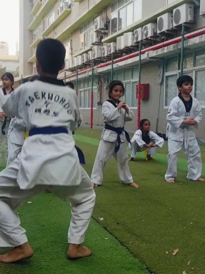 Students practice their stances and blocks. The mix of blue, green, and yellow belts shows the path of progression within our dojang.