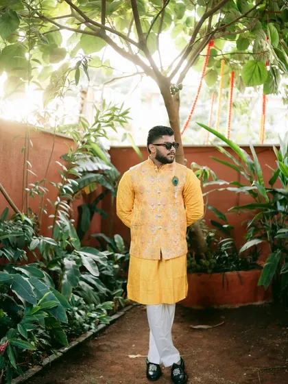 A portrait of the groom in a lush garden setting, capturing a moment of anticipation before the Haldi ceremony.