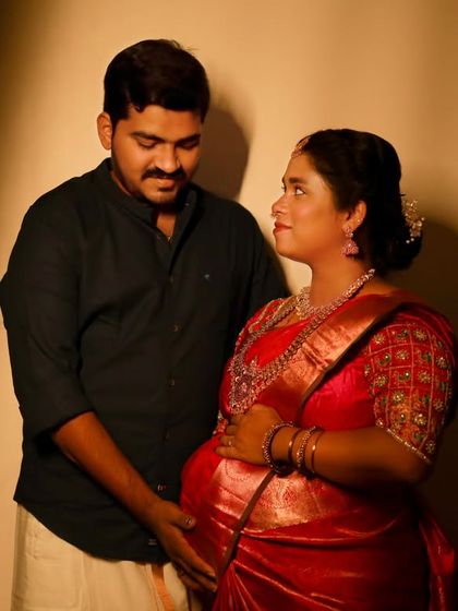 An intimate moment between a couple during their traditional maternity photoshoot. The dramatic lighting in our studio creates a warm and emotional portrait.